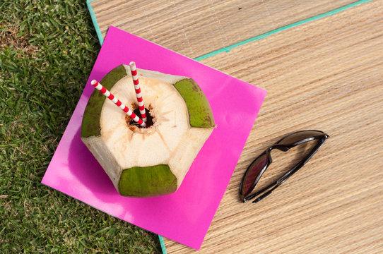 Coco sobre una alfombra de mimbre listo para ser bebida su agua