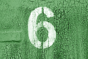 Number 6 in stencil on grungy metal wall in green tone.
