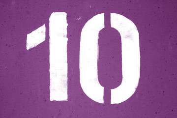 Number 10 in stencil on metal wall in purple tone.