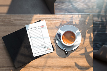 Cheque and coffee cup on wooden table in modern bright cafe. 3d rendering.