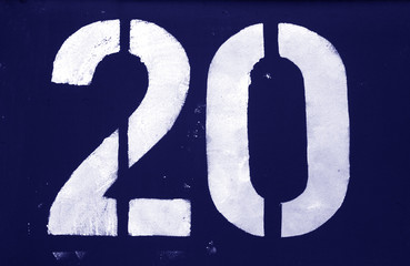 Number 20 in stencil on metal wall in blue tone.