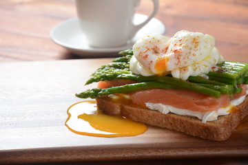 Poached egg with fried asparagus, cream cheese, salmon and spices on a toast. Poached egg with leak.Healthy French breakfast concept