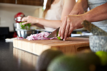 Midsection of couple preparing food in kitchen