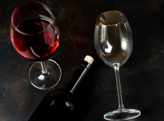 Bottle of wine and a glass of wine on a concrete background