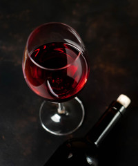 Bottle of wine and a glass of wine on a concrete background