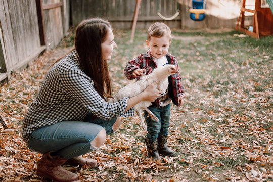Mother and son with hen outdoors