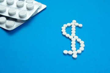 white pills in the shape of a dollar are scattered on a blue background next to a white packs with...