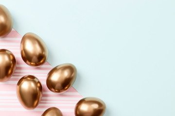 Golden eggs on blue and pink background