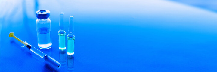 Syringes, medicine bottles on a blue background