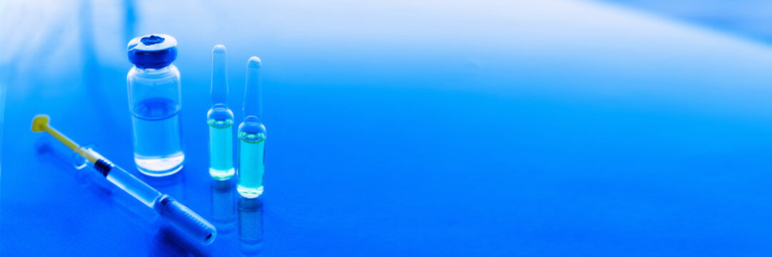 Syringes, medicine bottles on a blue background