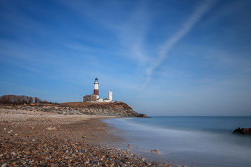 The Atlantic ocean meeting the east coast of Long Island, as the Montauk Lighthouse beacon sits at...