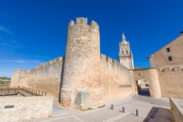 Fototapeta na wymiar exterior wall of Burgo de Osma medieval town, with public street and tower of cathedral, landmark and monument from thirteenth century, in Soria, Spain, Europe
