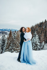 A ravishing couple go to the winter pine forest, a woman in a blue wedding dress, a man in a suit