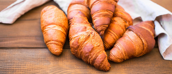 Fresh croisssants buns on wooden table, french croissants, fresh crusty breakfast croissants buns
