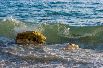 rocky sea shore with pebble beach, waves with foam
