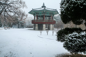 A Picture from the Yeouido park in Seoul in South Korea during the cold winter day and a snowfall. You can see one of the traditional wooden pavilions there. 