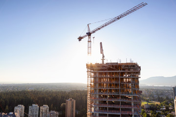 Aerial view of a residential building construction site during a vibrant summer sunset. Taken in Burnaby, Vancouver, BC, Canada. © edb3_16