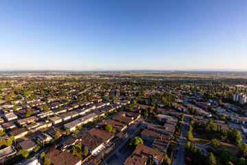 Aerial view of a residential suburban neighborhood during a vibrant summer sunset. Taken in Burnaby, Vancouver, BC, Canada.
