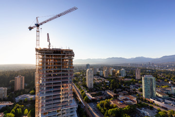Aerial view of a residential building construction site during a vibrant summer sunset. Taken in...