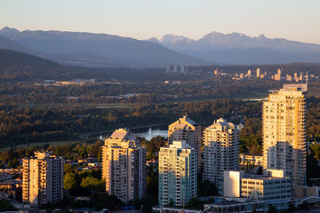 Obraz premium Widok z lotu ptaka na nowoczesne miasto podczas tętniącego życiem zachodu słońca. Zrobiono w Metrotown, Burnaby, Vancouver, BC, Kanada.