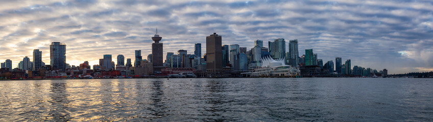 Fototapeta na wymiar Vancouver, BC, Canada - December 24, 2018: Panoramic view of a modern downtown city during a vibrant winter sunset.