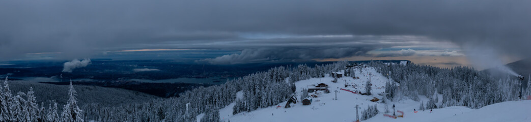 Panoramic view of Grouse Mountain Ski Resort during a cloudy winter sunset. Taken in North Vancouver, British Columbia, Canada.