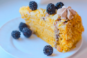 A piece of pecan pie with whipped cream and blackberries on a light background