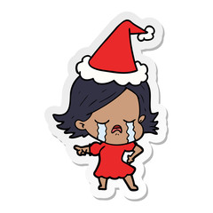 sticker cartoon of a girl crying and pointing wearing santa hat