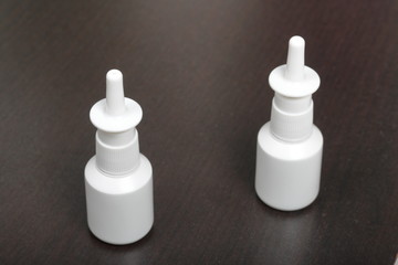 Nasal spray cans for the treatment of rhinitis. On a dark background.