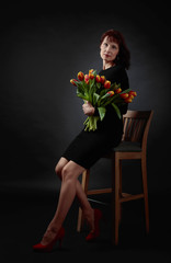 Attractive woman with a bouquet of red and yellow tulips.