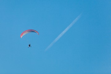 Hang-glider and condensation trace on the sky.