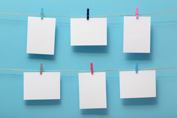 place for photo cards of moments of life, empty blanks attached to a linen rope with stationery clips on a colored background, a concept template for text, images, idea for home decor