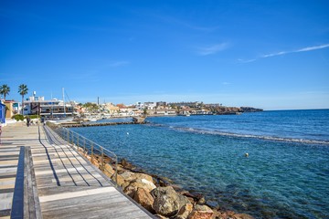 A wooden promenade over rocks follows the coastline in Cabo de Palos, Spain 