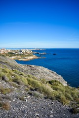 A top-down view with the small village of Cabo de Palos, Spain surrounded by deep blue water in the background.