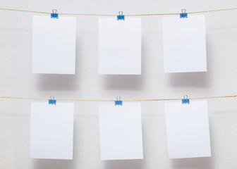papers for writing reminders in the office, useful decor, empty templates for text and photos on colored stationery clips on the background of white cotton fabric