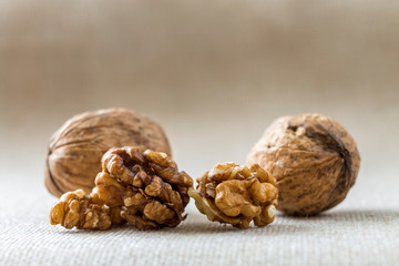 Close-up of walnuts, in wooden shell and kernels isolated on light copy space background. Healthy organic food concept.