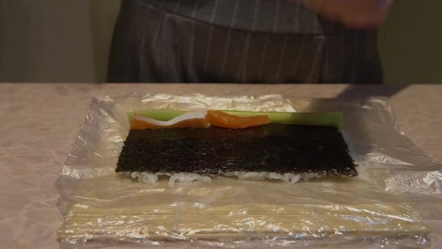 Close up of a woman preparing homemade sushi