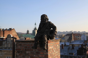 LVIV, UKRAINE - January 01, 2019: Sculpture a chimney sweep on the roof of the House of Legends