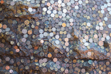 A large number of coins, a variety of styles placed according to