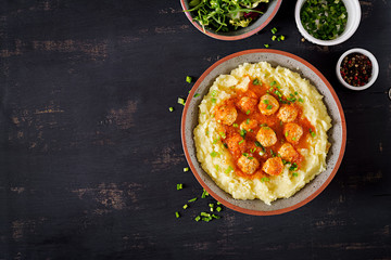 Meatballs in tomato sauce with mashed potatoes in bowl. Top view