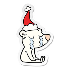 sticker cartoon of a crying sitting polar bear wearing santa hat