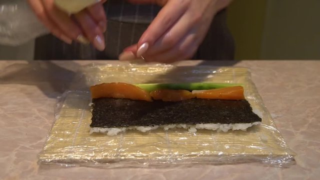 Close up of a woman preparing homemade sushi