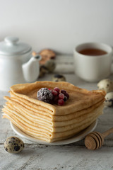 Stack of thin pancakes decorated with strawberries and blueberries. Russian holiday Maslenitsa. Healthy breakfast.