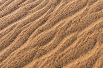 Amazing abstract background image of ripples and waves in the sand at sunrise
