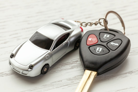 Car Keys With Remote Control Security And Car Key Chain On White Wooden Background