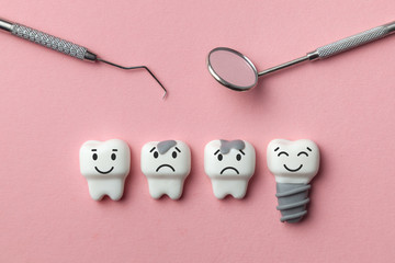 Healthy white teeth and implant are smiling and the tooth is sick with caries sad on pink background. Dentist tools mirror, hook.