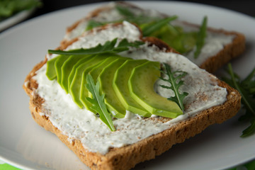 Avocado sandwich toast bread made with fresh sliced avocado, cream cheese. healthy food concept. Gray background. Food. Breakfast or snack.