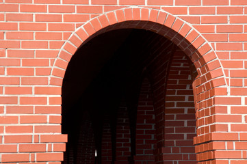 View of a finely crafted brick archway leading into a tunnel of more arches.