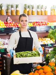 Salesgirl offering green beans