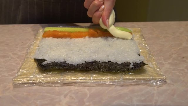 Close up of a woman preparing homemade sushi
